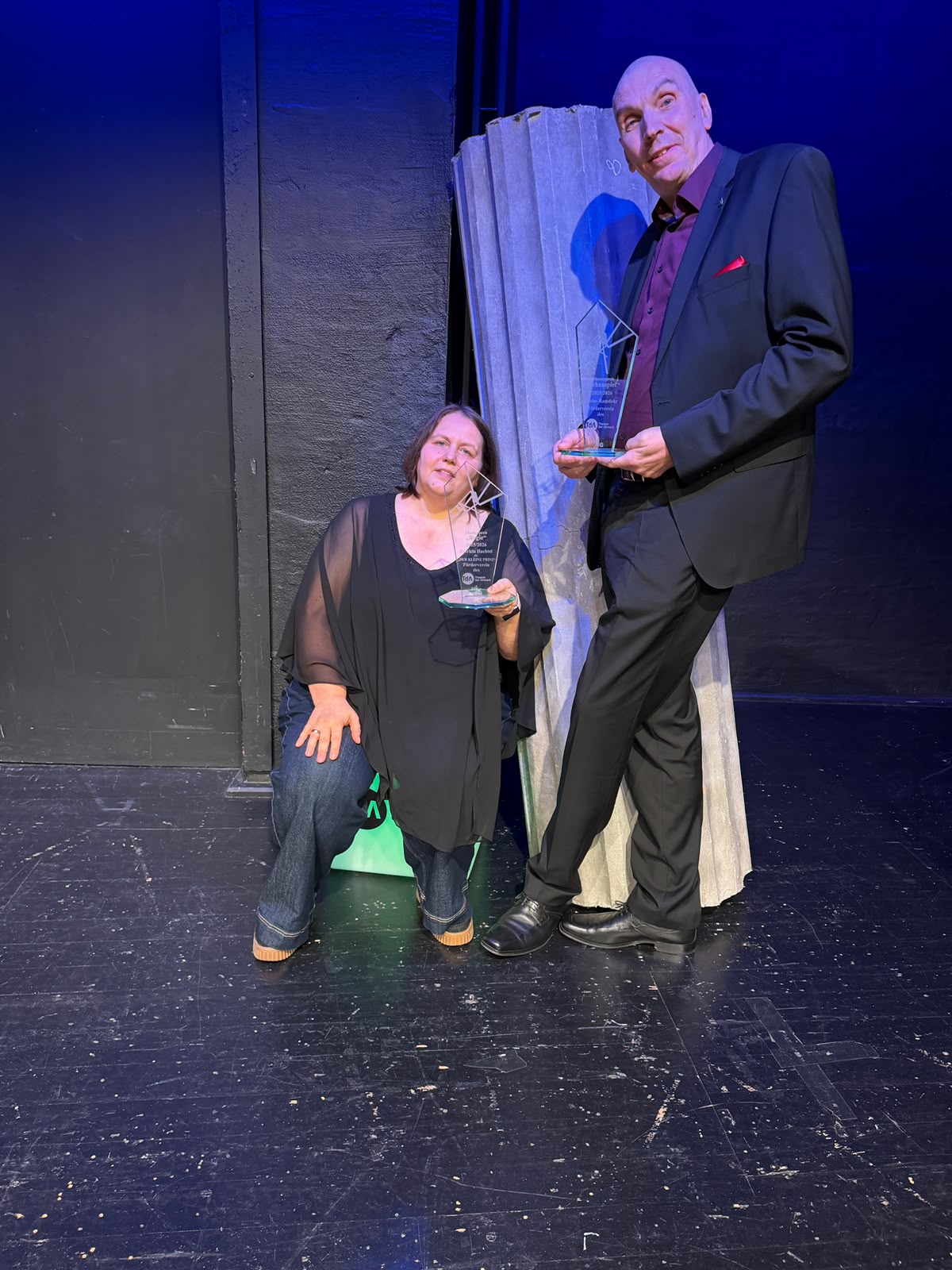 b32e5f86-ce6b-4e15-8e48-14cfbfaa661a Auf der Bühne Patricia Hachtel sitzend und Niclas Ramdohr mit dem Preis.